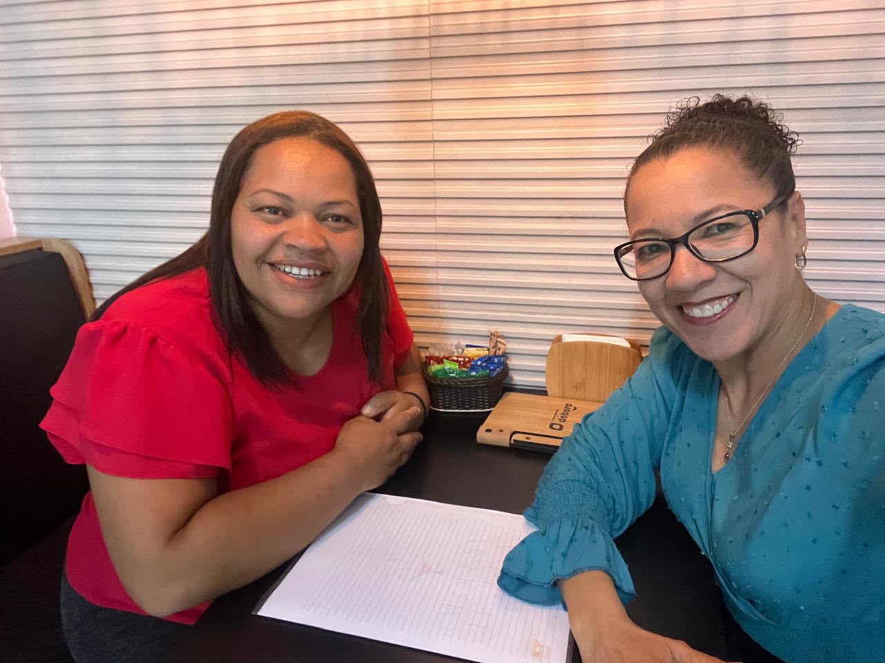 Duas mulheres sorrindo em uma mesa durante conexão do INSIDE