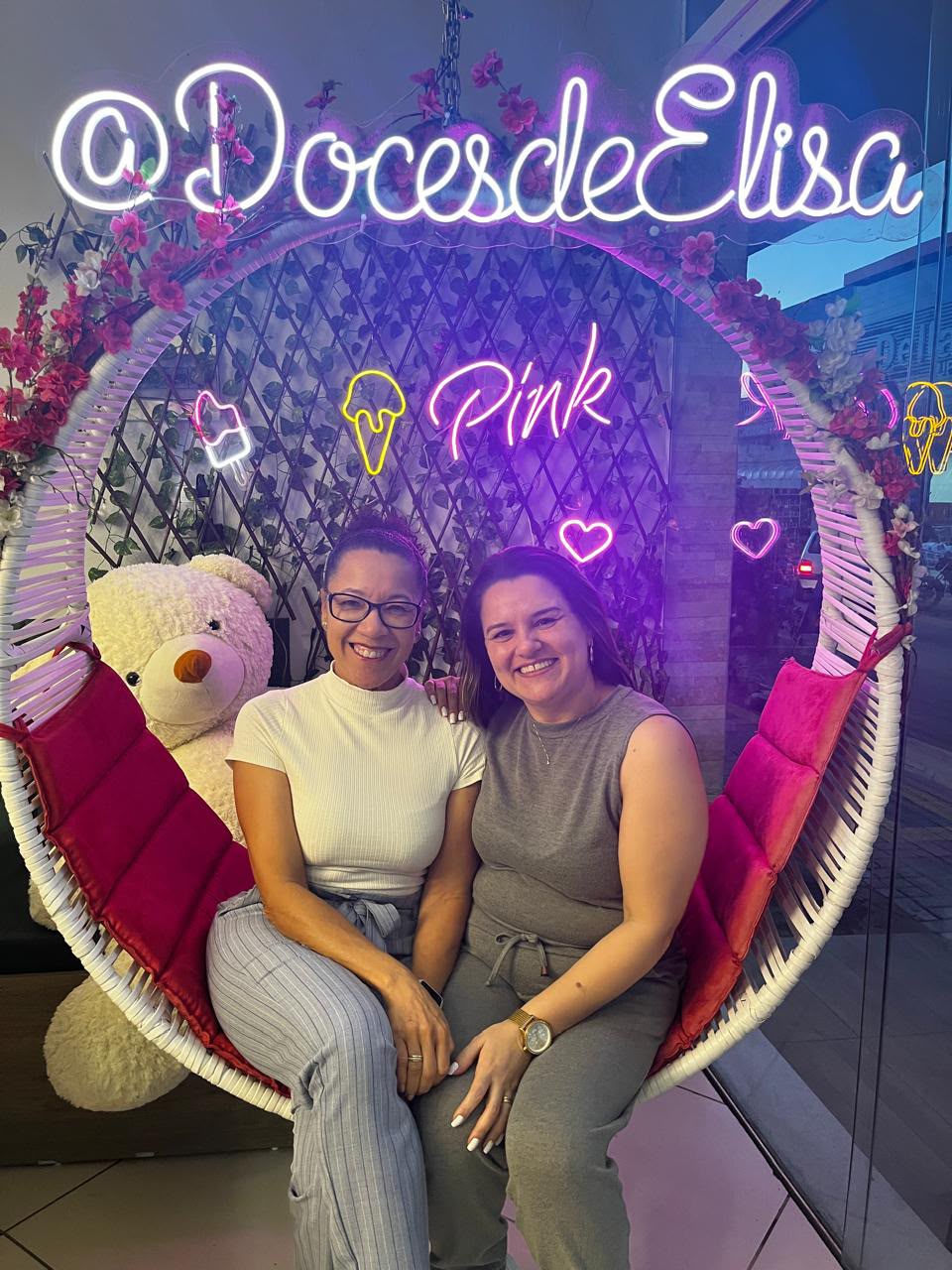 Duas mulheres sentadas em um espaço iluminado