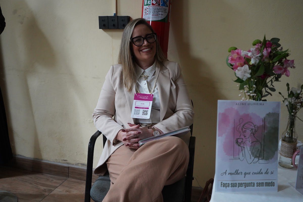 Participante sentada ao lado de materiais do encontro