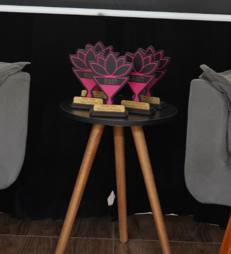 Troféus pink em formato de flor de lótus sobre a mesa do Transbordo